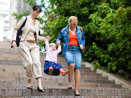 Three generation family on a park staircase - shallow DOF, focus on a little girl's faceの写真素材