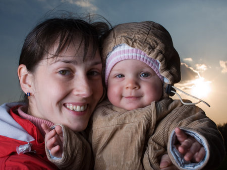 Portrait of baby with mom - against the sunの写真素材