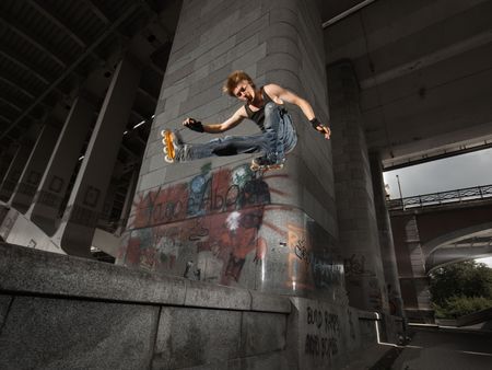 Wide angle shot of a jumping rollerskater on a dark urban background - with just a little motion blurの写真素材