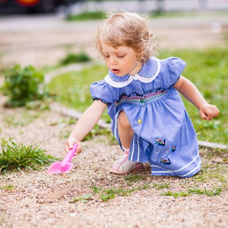 Little girl with a scoop on a playground - shallow DOFの写真素材