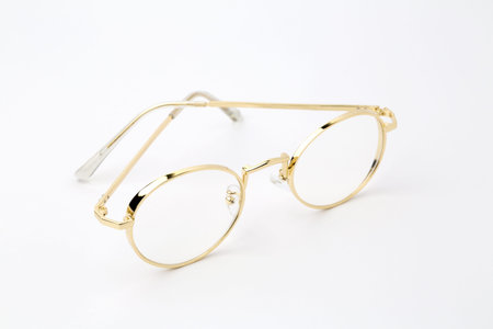 Classic gold round glasses on white backgroundの写真素材