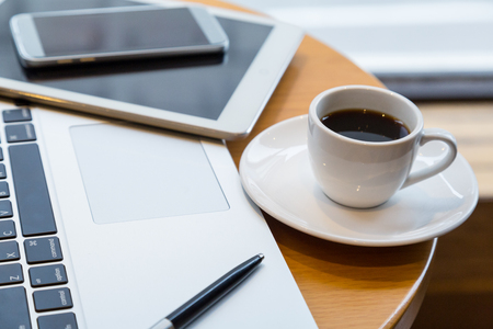 coffee cup, labtop and tablet on the round tableの写真素材