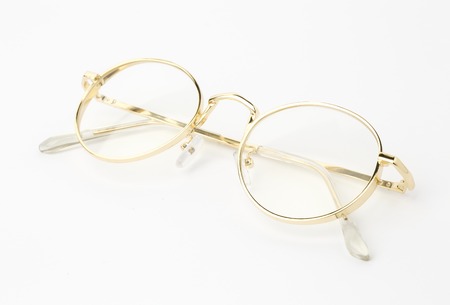 Classic gold round glasses on white backgroundの写真素材