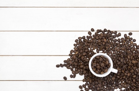 Coffee beans in coffee cup on white wood lot a coffee beansの写真素材