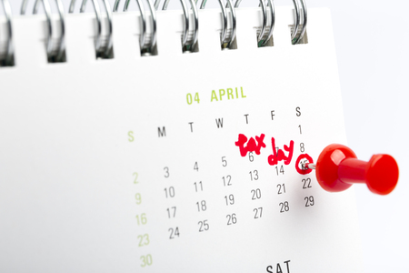 April tax day written and pinned in a calender, close up.の写真素材