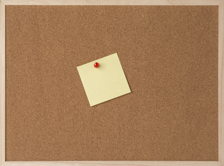 Sticky yellow note on wooden frame cork board.の写真素材