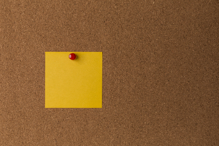 Sticky yellow note on cork board close up.の写真素材