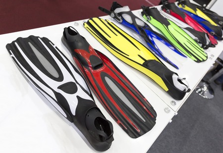 displayed colored swim fins on the white table.の写真素材