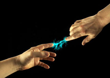 Sparks between fingertips of two people