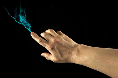 Finger firing lightning bolt. Black Background.の写真素材