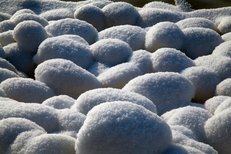 Snow stones covered with hard sunshineの写真素材