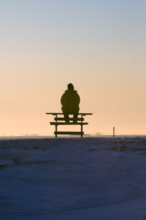Women sit on bench in sunriseの写真素材
