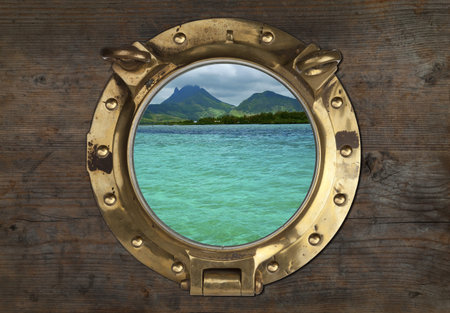 Antique Porthole with Tropical View on a wooden Wall Background. の写真素材