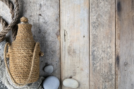 Bottle covered by tar rope with wooden backgroundの写真素材