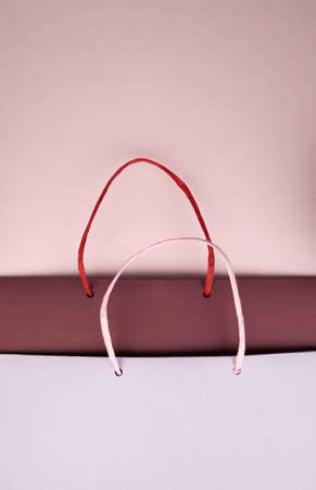 Paper bag with handles on pink cardboardの写真素材
