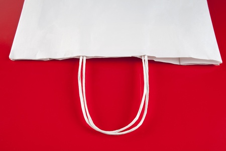 Paper bag with handles on red backgroundの写真素材