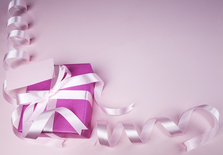 Gift box with ribbon on pink background の写真素材