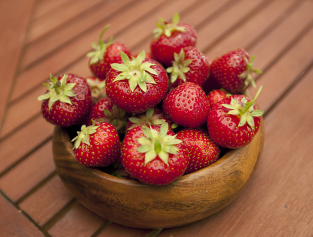Fresh strawberries in wood bowl on tableの写真素材