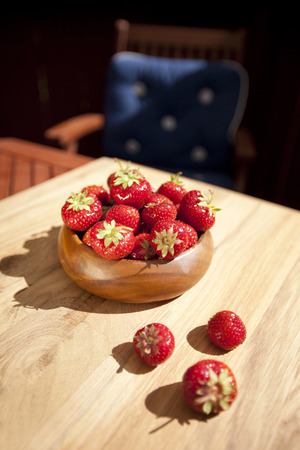 Fresh strawberries in wood bowl on tableの写真素材