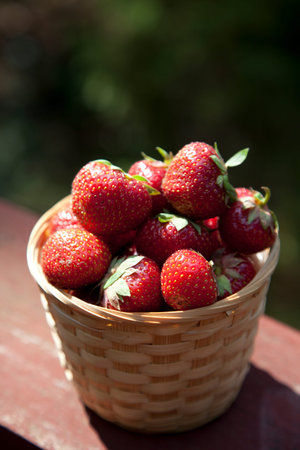 Fresh strawberry in basket on wooden table backgroundの写真素材