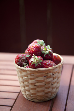 Fresh strawberry in basket on wooden table backgroundの写真素材