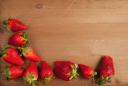 Ripe strawberries over wooden table backgroundの写真素材