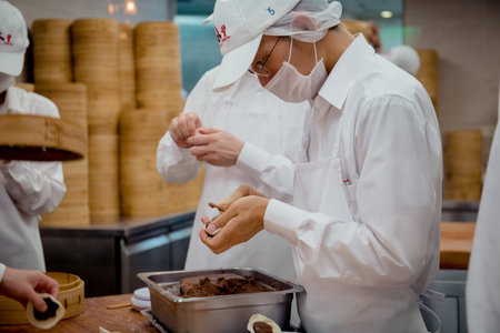 Taipei, Taiwan - 23 May, 2018: A group of skillful chef busying making the famous soup dumplings in...