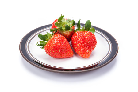 fresh garden strawberries on a white plateの写真素材