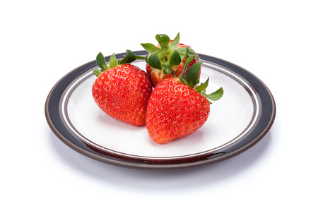 fresh garden strawberries on a white plateの写真素材