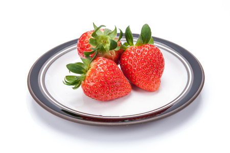 fresh garden strawberries on a white plateの写真素材