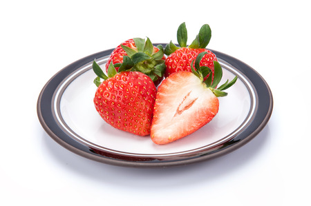 fresh garden strawberries on a white plateの写真素材