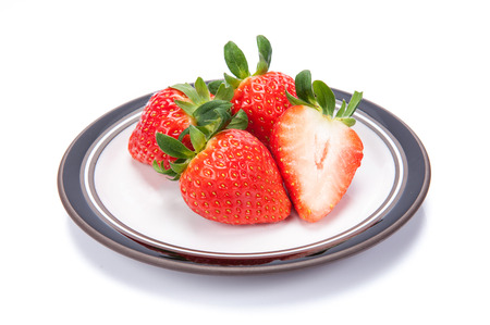 fresh garden strawberries on a white plateの写真素材