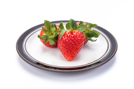fresh garden strawberries on a white plateの写真素材