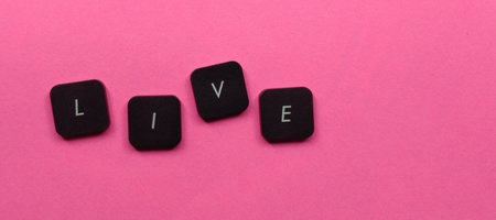 Live word made of black cubes on pink background, top view.の写真素材