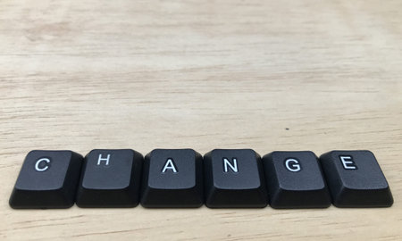 The word change written with black computer keyboard keys on wooden background.