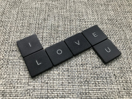 love word made of black plastic letter tiles on gray carpet background.の写真素材