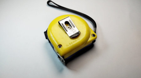 Yellow tape measure on a white background. Close-up. Selective focus.