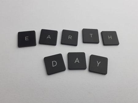 Earth Day. Black plastic buttons on white background. Copy space.