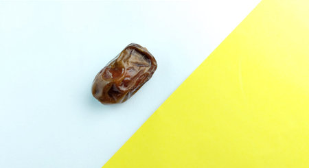 Dried date fruit on yellow and white background. Copy space.の写真素材
