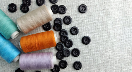 Spools of thread and buttons for sewing on a white background.の写真素材