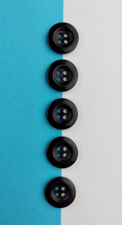 Black buttons on a blue and white background. View from above.の写真素材
