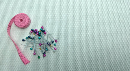 Sewing accessories on white fabric background. Sewing concept.