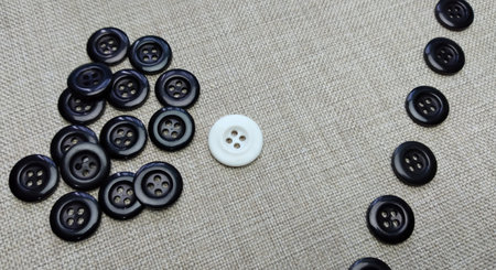 Black and white buttons on a linen cloth. Shallow depth of field.