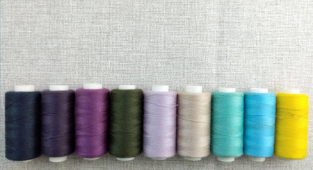 Sewing threads of different colors and sizes on a white background