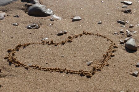 Heart shape in the sand on the beach with nice textureの写真素材