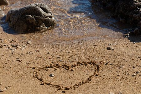 Heart shape in the sand on the beach with nice textureの写真素材
