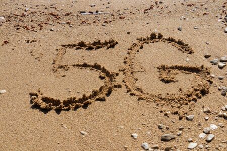5G written on the sandy beach near the seaの写真素材