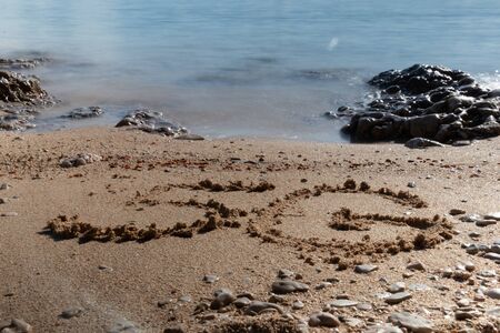 5G written on the sandy beach with sea wavesの写真素材