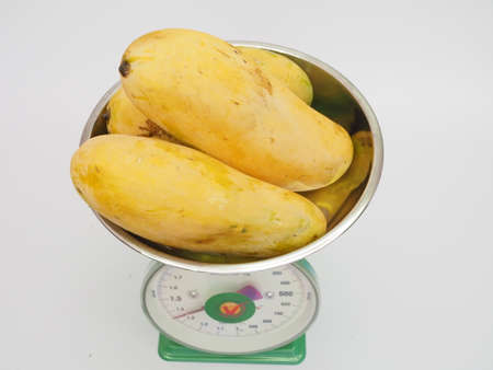 Ripe mangoes on weight scale. Suitable for groceries and fresh market concept.のeditorial素材