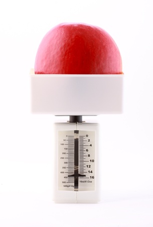 Red apple being weighed isolated on whiteの写真素材